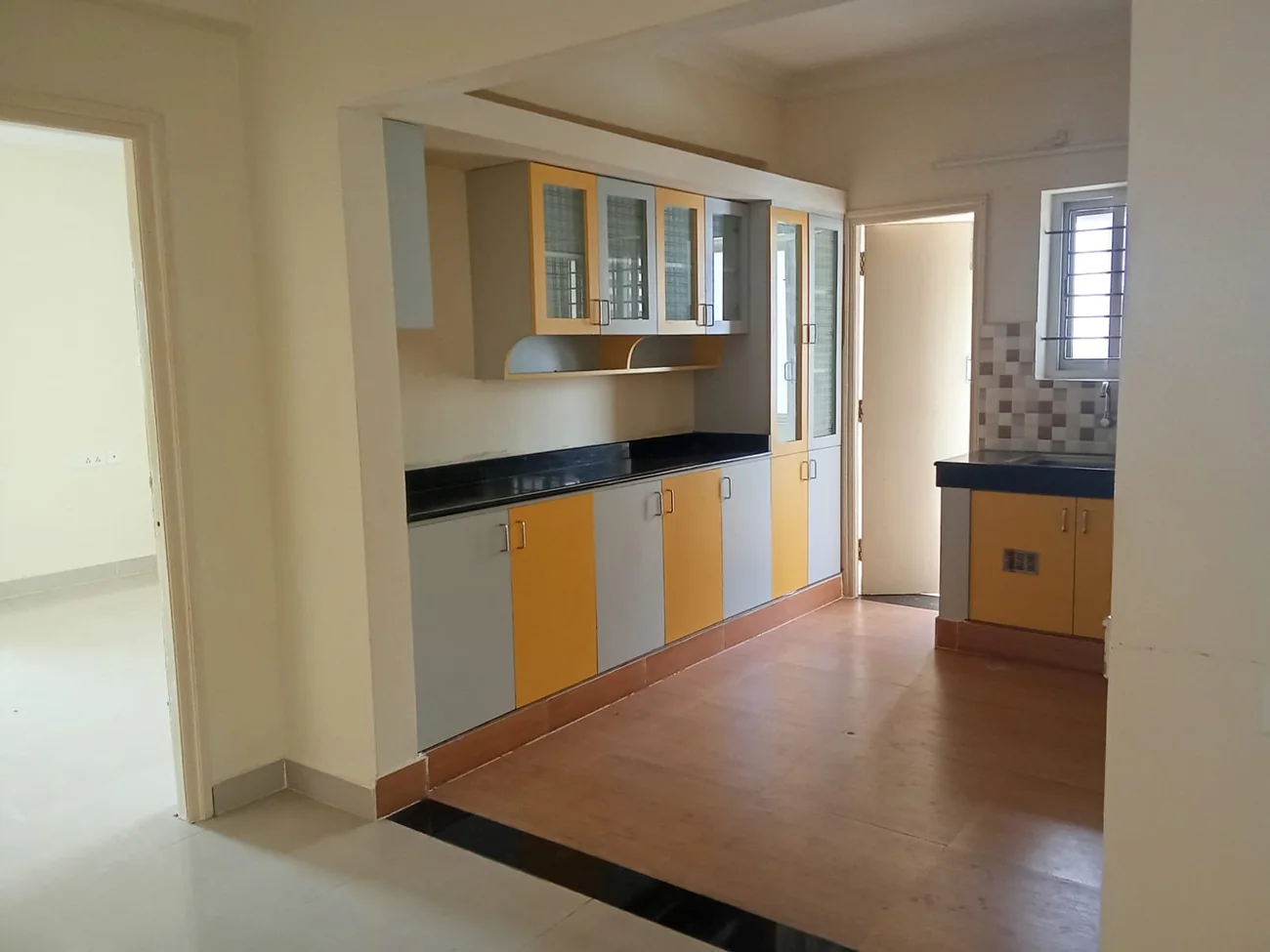Kitchen with a tiled backsplash and tiled flooring completed by KovaiBuild